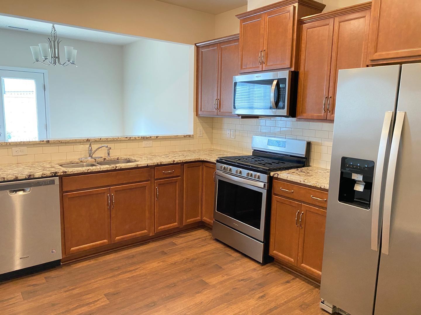 1005 Saffron Loop Durham, NC 27713 - Photo 8 of 26 a kitchen with granite countertop stainless steel appliances and wooden cabinets