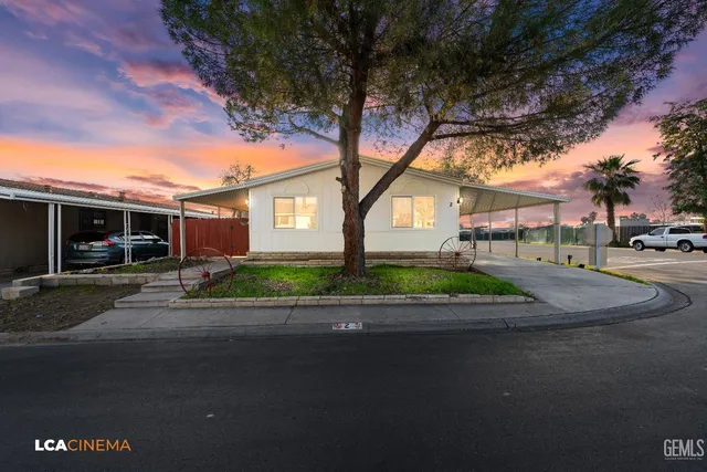 a front view of a house with garden and trees