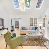 a living room with furniture a fireplace a chandelier and windows
