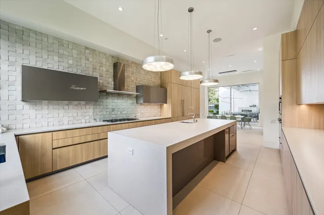 a kitchen with stainless steel appliances granite countertop a sink a stove top oven a counter space and cabinets