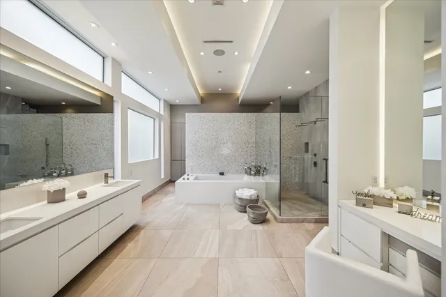 a spacious bathroom with a double vanity sink large mirror and a bathtub