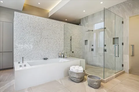 a bathroom with a tub shower sink and mirror