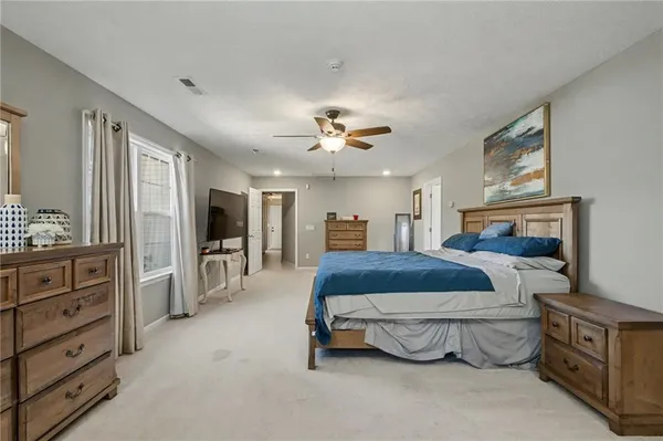 a spacious bedroom with a bed and a dresser