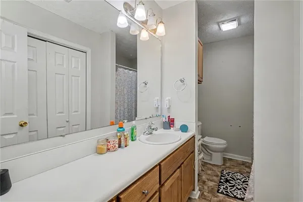 a bathroom with a sink a toilet and a mirror