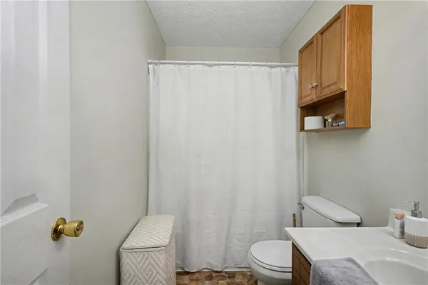 a bathroom with a toilet and a shower curtain