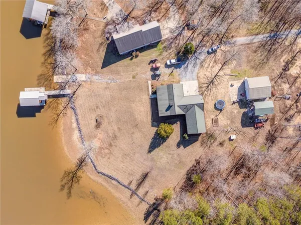 an aerial view of a house with a yard and covered with snow