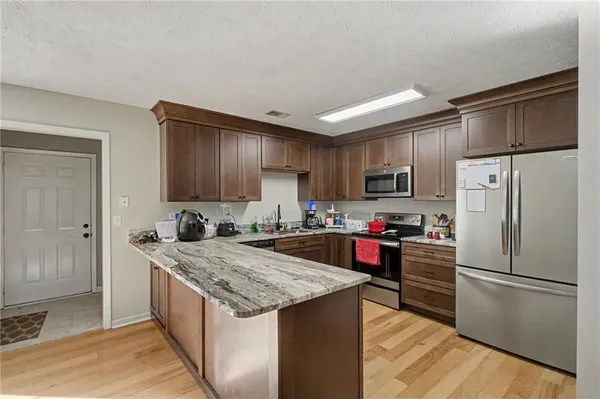 a kitchen with stainless steel appliances granite countertop a refrigerator stove microwave and sink
