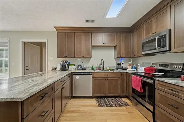 a kitchen with stainless steel appliances granite countertop a stove sink microwave and cabinets