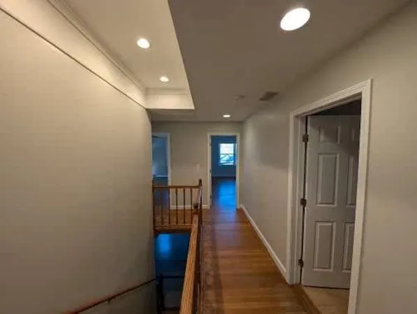 a view of a hallway with wooden floor