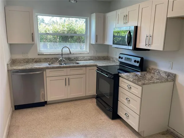 a kitchen with granite countertop a sink and a stove