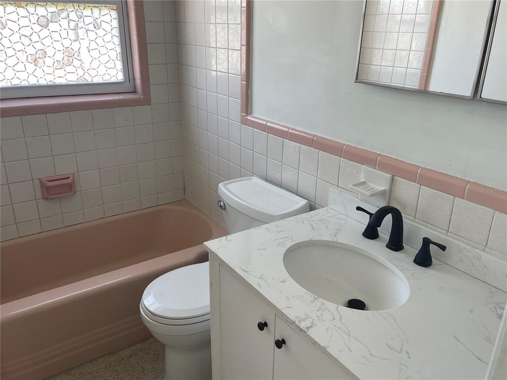 3076 Grand View Avenue Clearwater, FL 33759 - Photo 8 of 15 a bathroom with a sink a toilet and bathtub