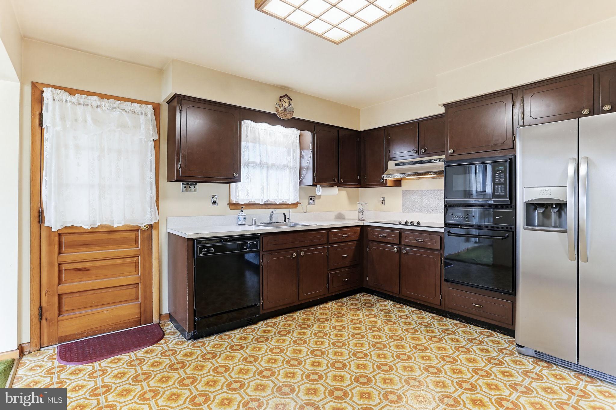 9301 Gardenia Road Baltimore, MD 21236 - Photo 16 of 37 a kitchen with a refrigerator sink and cabinets
