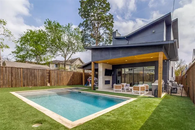 a view of a backyard with swimming pool table and chairs