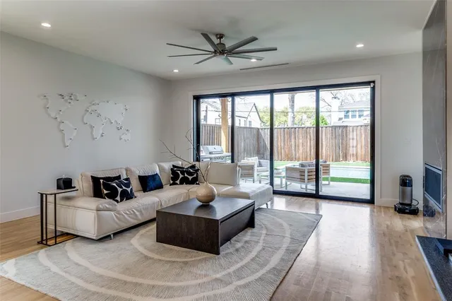 a living room with furniture and a large window with wooden floor