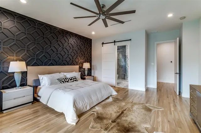 a bedroom with a large bed and a chandelier