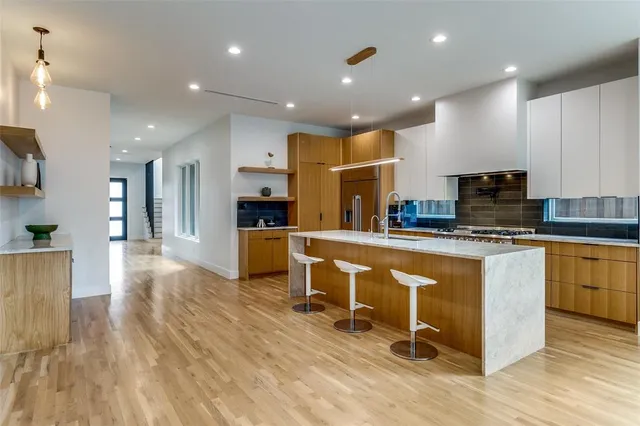 a kitchen with stainless steel appliances kitchen island granite countertop a stove a sink a refrigerator and a cabinets