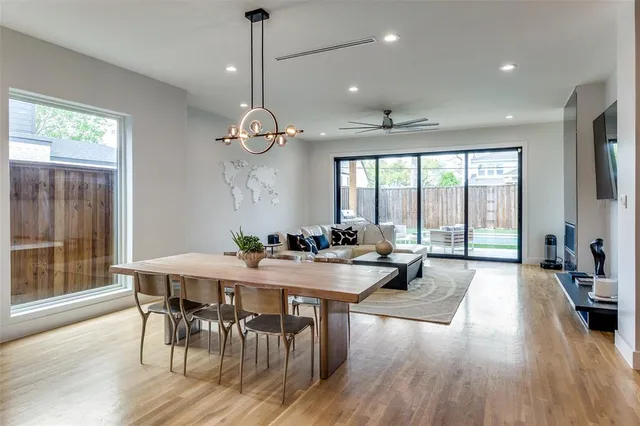 a very nice looking dining room with a large window table and chairs