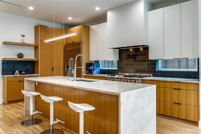 a kitchen with stainless steel appliances granite countertop a sink and a stove