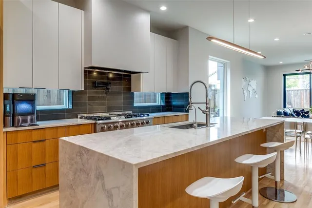 a large kitchen with granite countertop a sink and a stove