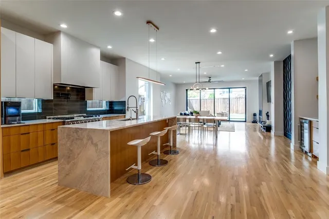 a kitchen with sink wooden floor dining table and chairs