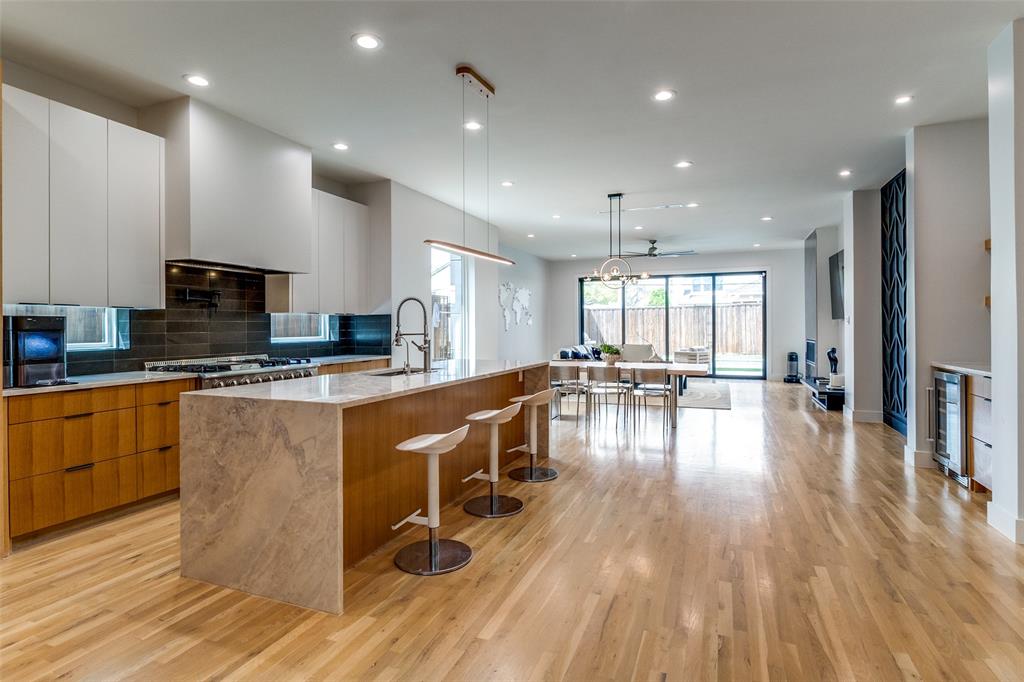 6215 Llano Avenue Dallas, TX 75214 - Photo 10 of 38 a kitchen with sink wooden floor dining table and chairs