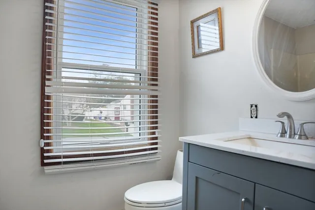 a bathroom with a sink a toilet and a mirror