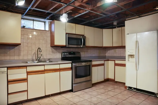 a kitchen with cabinets stainless steel appliances and a sink