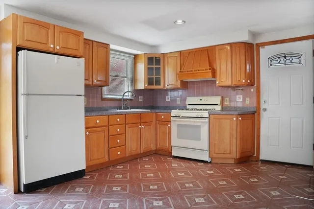 a kitchen with white cabinets and white appliances