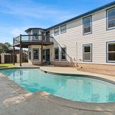 a view of a house with a swimming pool and a yard