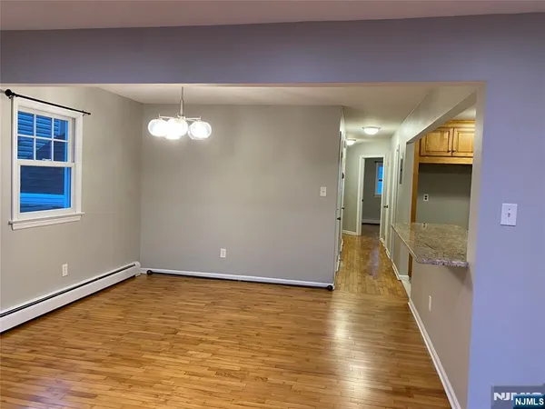 a view of a room with wooden floor and a window