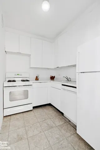 a white kitchen with sink and white stainless steel appliances