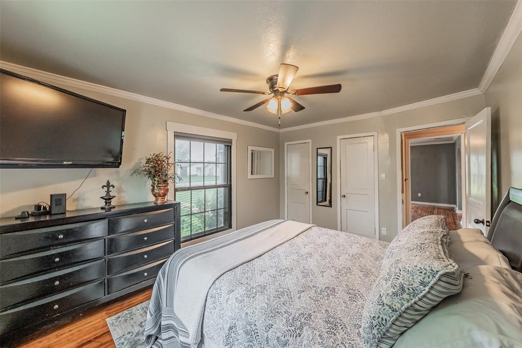 1802 Keneipp Road Carrollton, TX 75006 - Photo 9 of 22 The property includes a bedroom with wood flooring, a ceiling fan, and a window that provides natural light