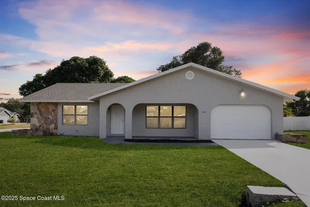 a front view of a house with a garden and yard