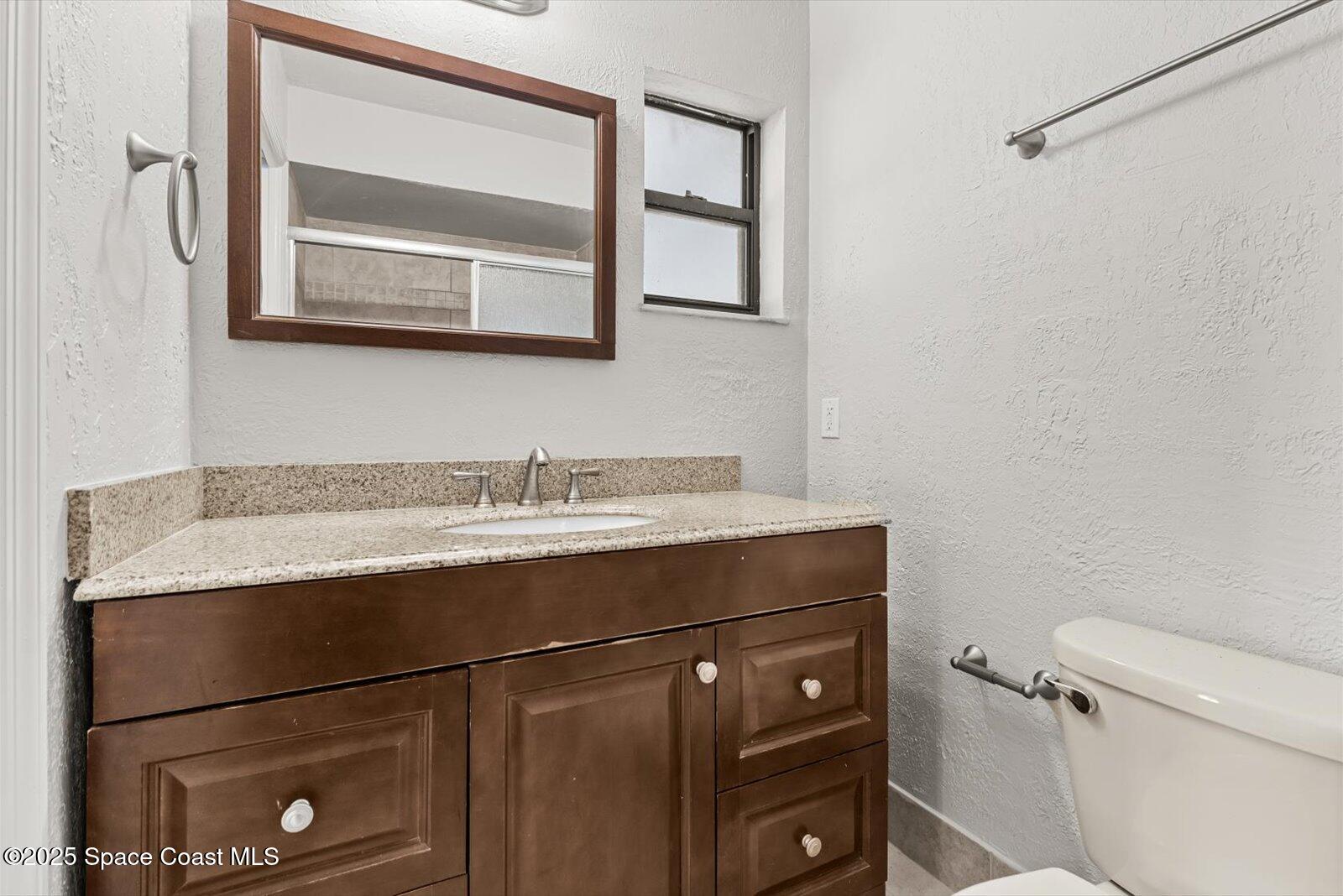 402 Southwest Sansom Lane Port St. Lucie, FL 34953 - Photo 15 of 33 a bathroom with a granite countertop sink toilet and mirror