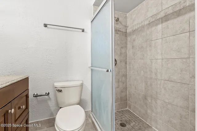 a white toilet sitting next to a shower