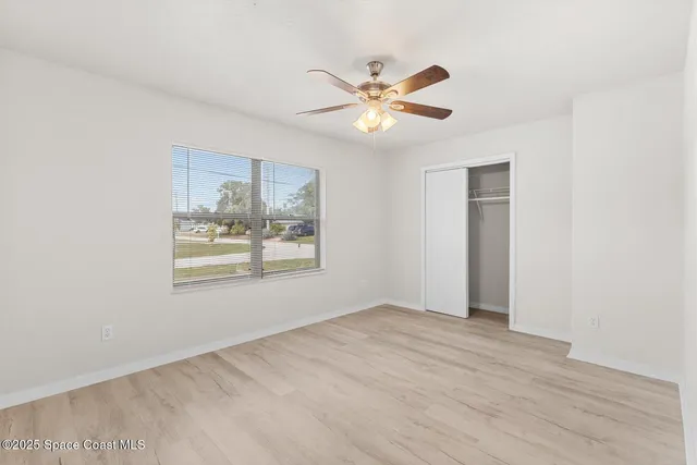 a view of a big room with wooden floor and windows in a room