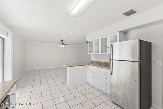 a kitchen with white cabinets a refrigerator and a stove