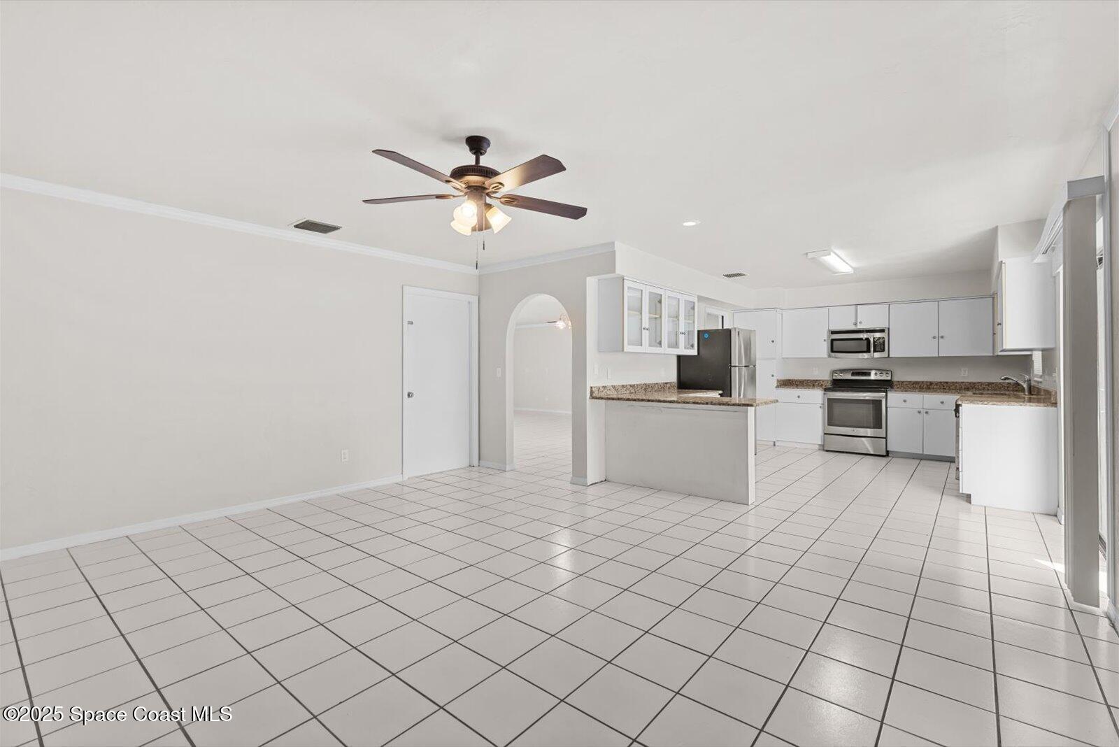 402 Southwest Sansom Lane Port St. Lucie, FL 34953 - Photo 6 of 33 a large white kitchen with a stove a sink dishwasher and a refrigerator with wooden floor