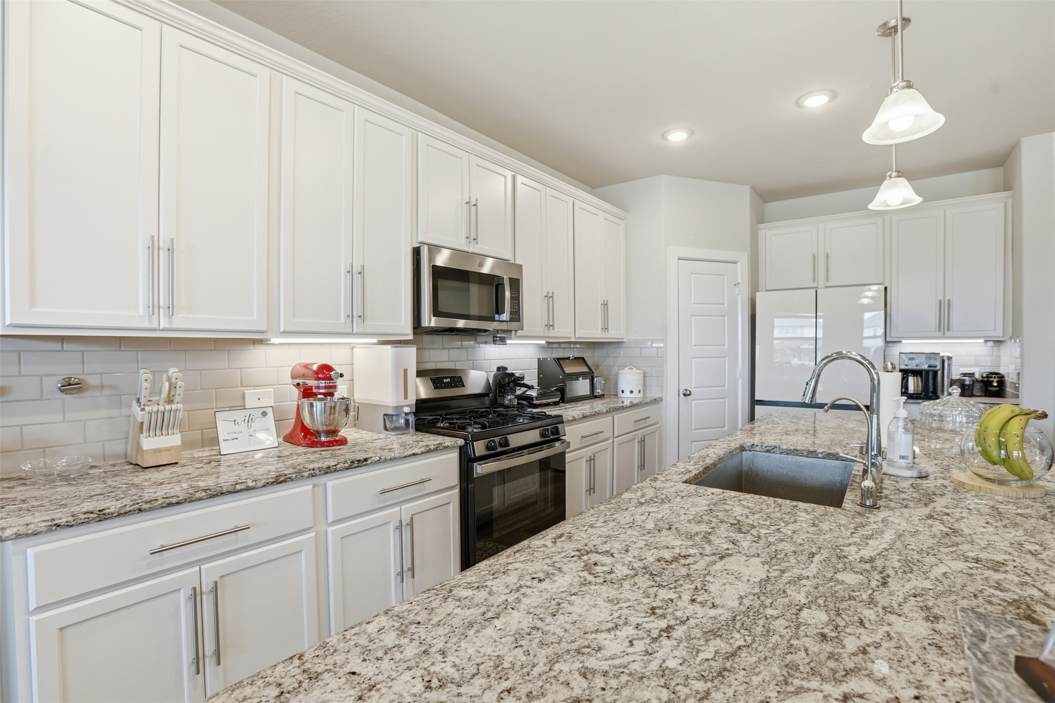 2725 Arbor Edge Crossing La Marque, TX 77568 - Photo 13 of 38 a kitchen with granite countertop a sink stove and cabinets