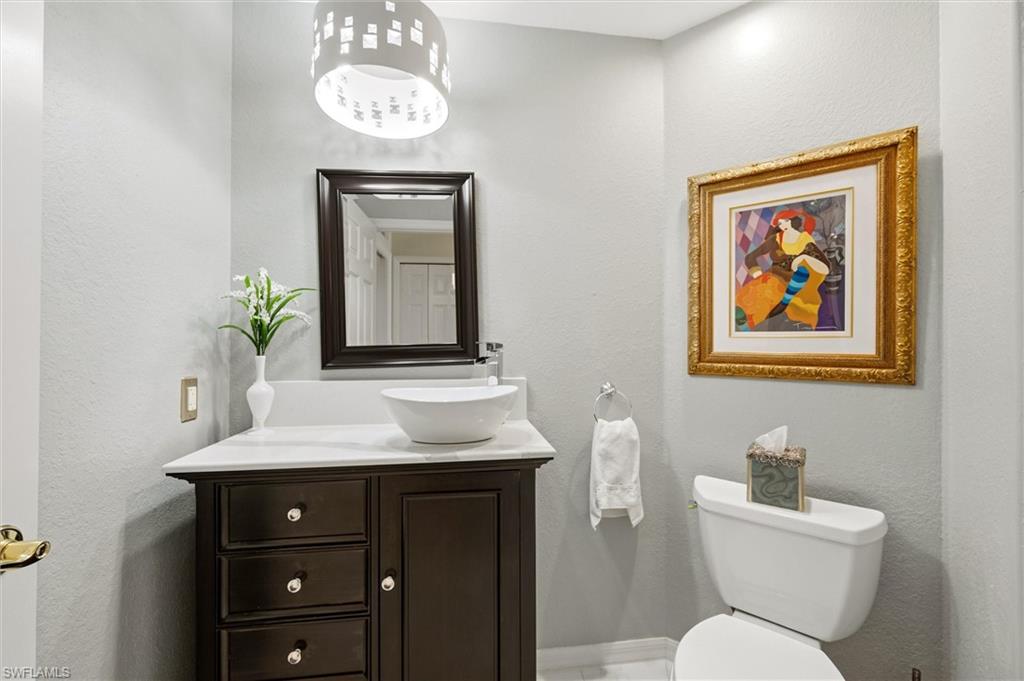 3033 Olde Cove Way Naples, FL 34119 - Photo 36 of 49 Bathroom with a textured wall and vanity