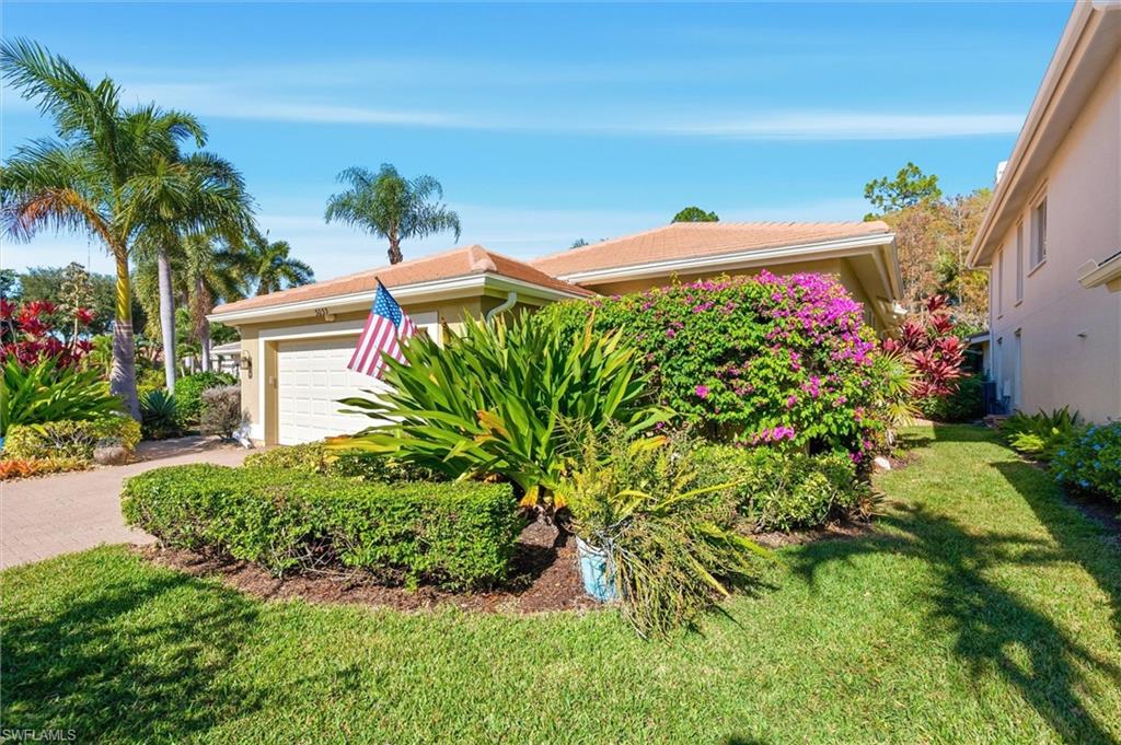 3033 Olde Cove Way Naples, FL 34119 - Photo 4 of 49 View of front of property with an attached garage, a front lawn, stucco siding, and driveway