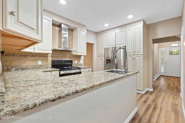 an empty room with wooden floor ceiling fan and windows