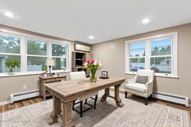 a view of an empty room with wooden floor fireplace and a window