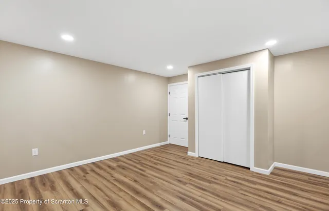 an empty room with windows and ceiling fan