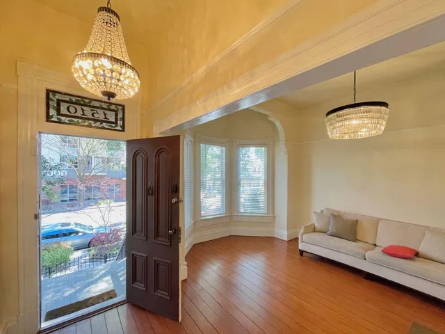 a view of a room with furniture and wooden floor