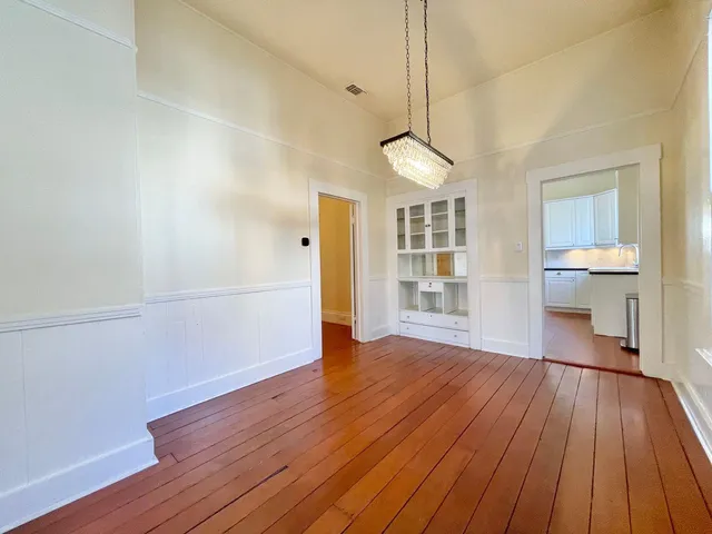 a view of empty room with wooden floor and window