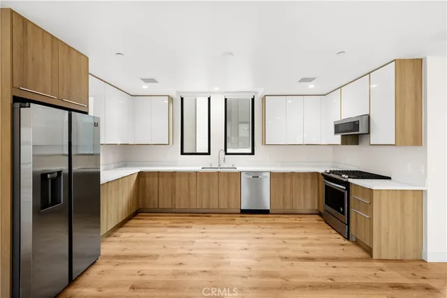 a large kitchen with a large window and stainless steel appliances