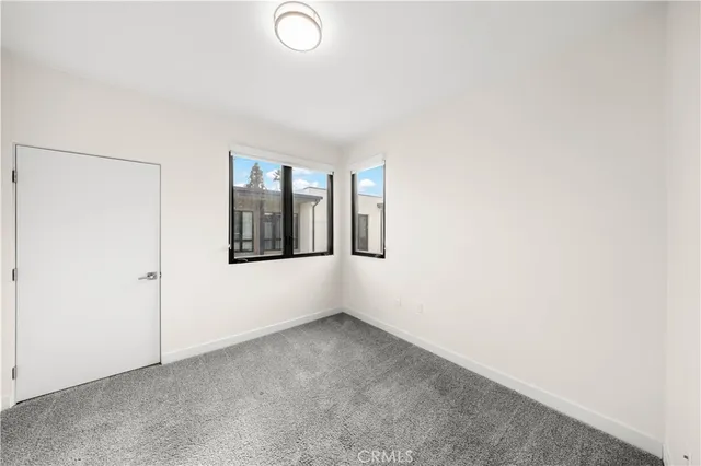 an empty room with windows and closet