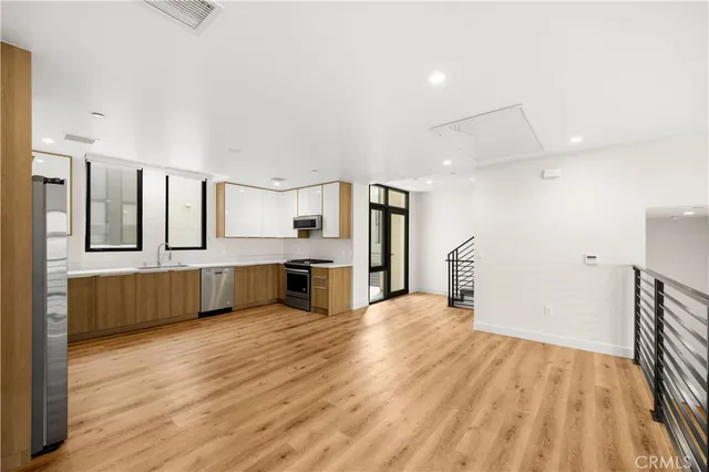 a large kitchen with a lot of counter space and wooden floor