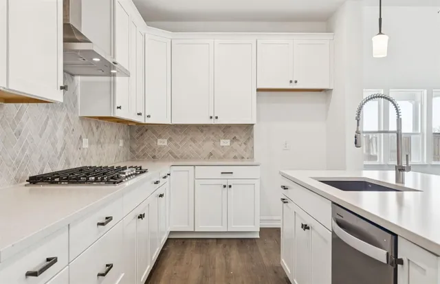 a kitchen with granite countertop white cabinets and a stove